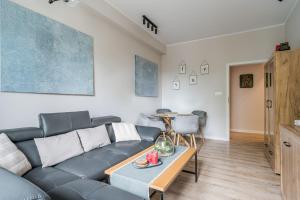 a living room with a couch and a table at Apartament przy Stajennej in Gdańsk