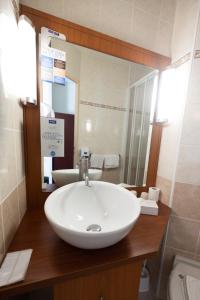 a bathroom with a white sink and a mirror at Kyriad Chateauroux in Châteauroux