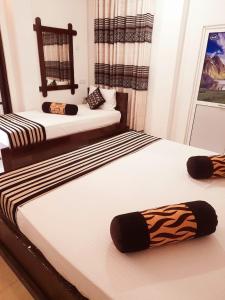 duas camas sentadas uma ao lado da outra num quarto em Heritage Rangiri Villa em Dambulla