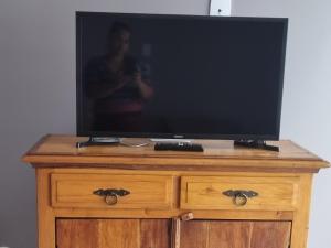 uma televisão em cima de uma cómoda de madeira em Casa no Moradas em Pelotas