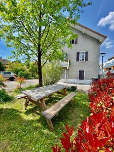 una mesa de picnic de madera frente a una casa en Un peu plus prés des étoiles, en Annecy