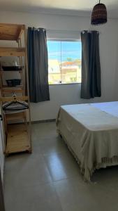 een slaapkamer met een bed en een raam bij Porto Ville Home - AP 2 quartos in Porto Seguro