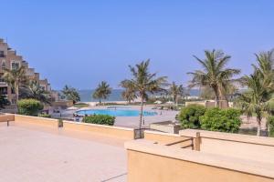 un complejo con piscina y palmeras en Sensational 1BR in Bab Al Bahar with Beach Access, en Ras al Khaimah