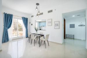 a white dining room with a table and chairs at Sensational 1BR in Bab Al Bahar with Beach Access in Ras al Khaimah