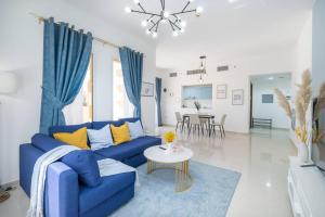 a living room with a blue couch and a table at Sensational 1BR in Bab Al Bahar with Beach Access in Ras al Khaimah