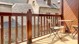 a balcony with a wooden railing and two chairs at Saplan Real Estate MALADETA in Gessa