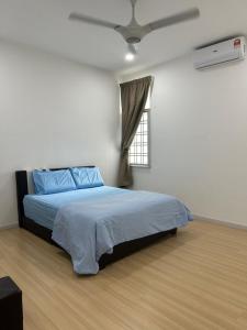 - une chambre avec un lit et un ventilateur de plafond dans l'établissement Mr.J Homestay, à Taiping