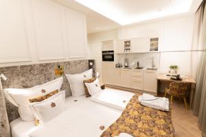 un soggiorno con mobili bianchi e una cucina di SCHLOSSRESIDENZ - Boutique Apartments & Hotel Suiten a Schloß Ricklingen