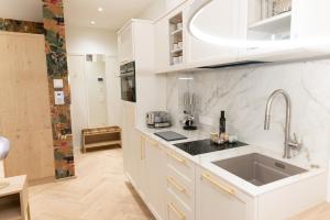 a kitchen with white cabinets and a sink at SCHLOSSRESIDENZ - Boutique Apartments & Hotel Suiten in Garbsen +269 photos