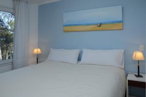 a bedroom with a white bed and a window at Jaina Resort & Spa in Mar de las Pampas