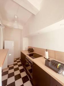 eine Küche mit schwarz-weiß kariertem Boden in der Unterkunft Cocon douillet à Agde in Agde