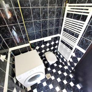 een badkamer met een toilet en een zwart-witte tegelvloer bij Relax to the max with the sea view in Medulin