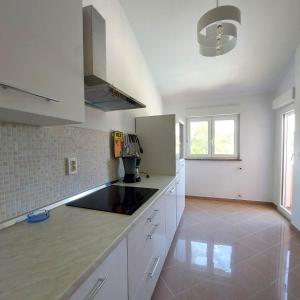 a kitchen with white cabinets and a black counter top at Relax to the max with the sea view in Medulin
