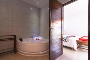 een badkamer met een bad en een slaapkamer bij Villas Anna Bali in Lovina