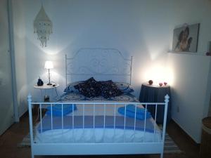 シラクーサにあるCasa del Vicoloのベッドルーム(白いベッド、青い枕付)
