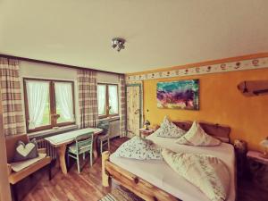 1 dormitorio con 2 camas, mesa y escritorio en Ferienwohnungen Berghof, en Krün