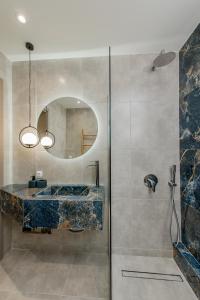 a bathroom with a sink and a shower with a mirror at Gemela AllstarBoutique in Aegina A in Aegina Town