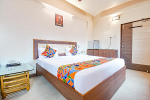 um quarto com uma cama grande e uma mesa em FabHotel Shreeyash Residency em Pune