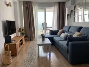 塞辛布拉的住宿－Sesimbra Balcony，客厅配有蓝色的沙发和电视