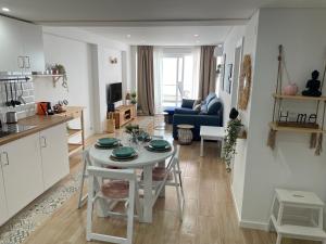 een keuken en woonkamer met een witte tafel en stoelen bij Sesimbra Balcony in Sesimbra