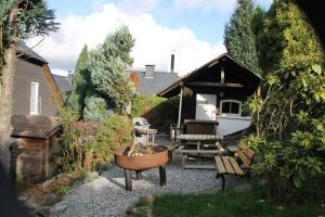 einen Garten mit einer Bank, einem Tisch und einem Haus in der Unterkunft Ferienhaus Winterberg für 12 Personen Sauna Garten Garage Hund in Winterberg