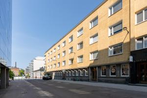 タンペレにある2ndhomes Tampere "Koskipuisto" Apartment - Downtown 1BR Apt with Saunaの大きなレンガ造りの建物の横の空き道