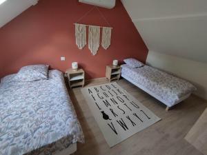 an attic bedroom with two beds and a rug at Maison de campagne avec terrain in Vallon-en-Sully