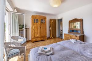 um quarto com uma cama, uma cadeira e um espelho em Ferienwohnung Lammerberg em Albstadt