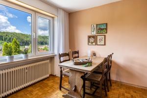 uma sala de jantar com uma mesa e cadeiras e uma janela em Ferienwohnung Lammerberg em Albstadt
