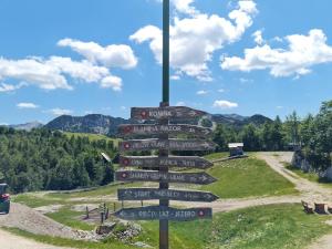 una señal direccional en una colina en las montañas en Chalet Burja at Vogel mountain - cable car access or hiking - not reachable with car, en Bohinj