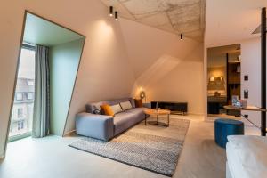 ein Wohnzimmer mit einem Sofa und einem Tisch in der Unterkunft MIANO Hotel & Bar in München