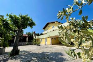 a yellow house with a tree in front of it at Top Apartments in Šilo