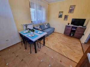 ein Wohnzimmer mit einem Tisch und einem Sofa in der Unterkunft Apartment in Crikvenica 40895 in Crikvenica