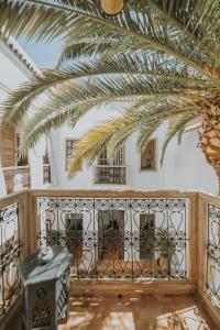 une chambre avec une clôture et un palmier dans l'établissement Dar Zelda, à Marrakech