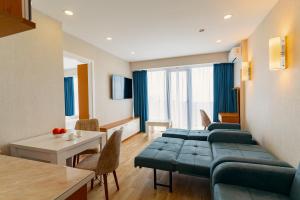 een woonkamer met een bank en een tafel bij Orbi Beach 33 floor with great view in Batoemi