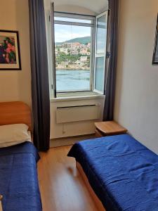 a bedroom with two beds and a window at Seafront apartment Marina2 in Jelsa