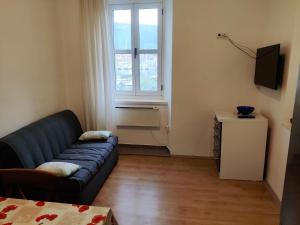 ein Wohnzimmer mit einem Sofa und einem Fenster in der Unterkunft Seafront apartment Marina2 in Jelsa