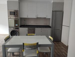 a kitchen with a table and chairs and a refrigerator at Canadina 1 in Morgovejo