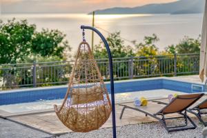 a hammock hanging next to a chair next to a pool at Seaview Villa Lavanda with pool in Budva
