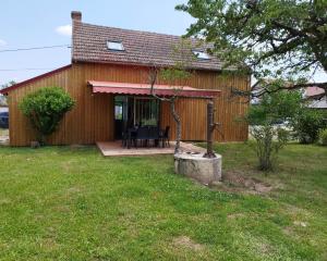 a wooden house with a table and chairs in a yard at Maison de campagne avec terrain in Vallon-en-Sully