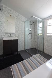 een badkamer met een glazen douche en een wastafel bij 79, Ruime chalet aan de Kampina in Oisterwijk