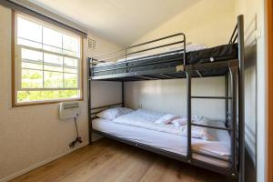 een kamer met 2 stapelbedden en een raam bij 79, Ruime chalet aan de Kampina in Oisterwijk