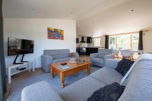 een woonkamer met twee banken en een tafel bij 79, Ruime chalet aan de Kampina in Oisterwijk