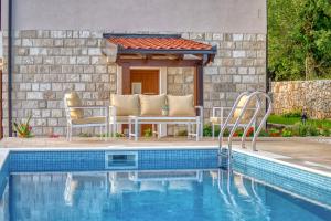 a swimming pool with two chairs next to a house at Seaview Villa Lavanda with pool in Budva