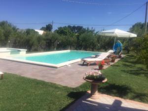 a swimming pool with chairs and an umbrella at Paraiso in Mafalda