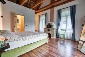 sypialnia z łóżkiem i kominkiem w obiekcie Maison BOGArT w mieście Alsobogát
