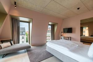 a bedroom with a large bed and a large window at MIANO Hotel & Bar in Munich