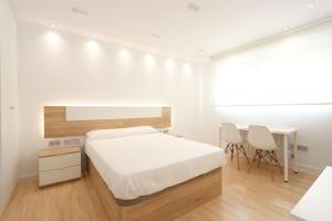 1 dormitorio con 1 cama, mesa y sillas en Apartamento LA BEJARANA, en Béjar