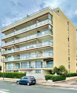 un coche aparcado delante de un gran edificio en Appartement Le Schooner, en Roquebrune-Cap-Martin