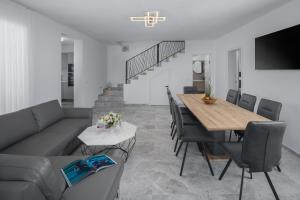 uma sala de estar com um sofá, uma mesa e cadeiras em Villa IN em Nova Vas